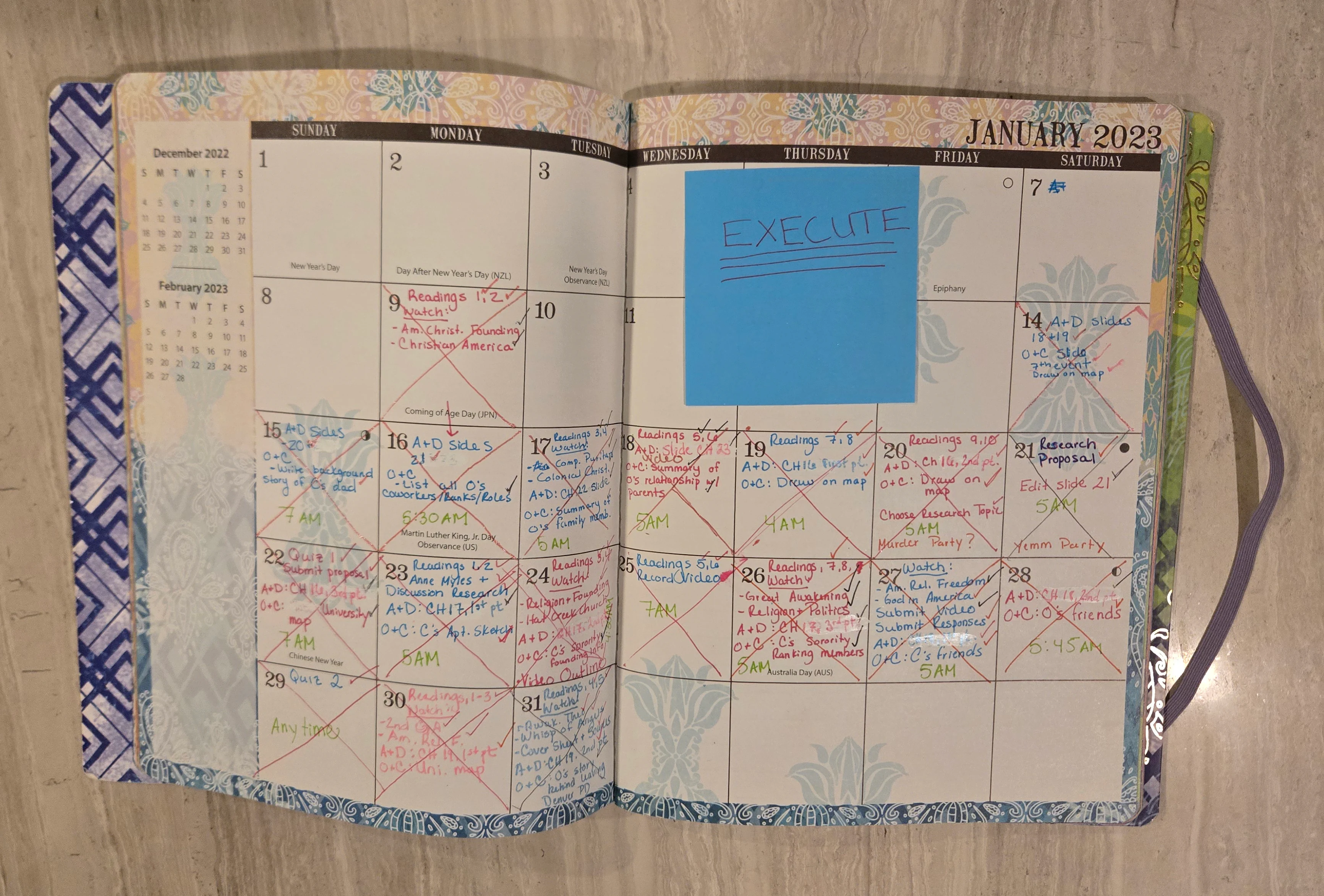 The monthly planner open to January 2023 with chapter deadlines and an EXECUTE sticky note